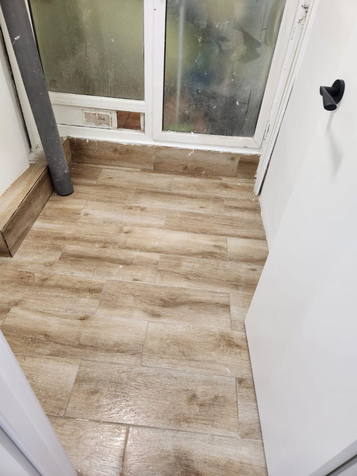 Detalle de suelo laminado efecto madera instalado durante reforma en Barcelona